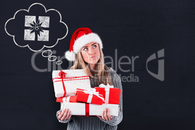 Composite image of festive blonde holding pile of gifts