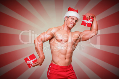 Composite image of shirtless macho man in santa hat holding gift