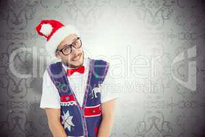 Composite image of geeky hipster in santa hat