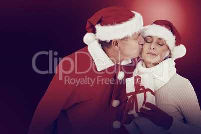 Festive mature couple holding gift