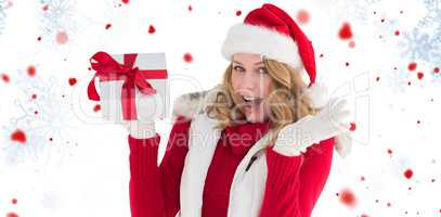 Composite image of excited blonde in santa hat holding gift