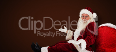 Composite image of santa sits leaned on his bag and has no clue