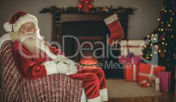 Festive santa claus sitting on couch at christmas