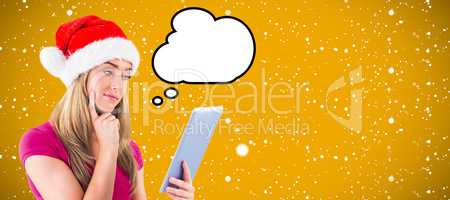 Composite image of festive blonde looking at tablet pc