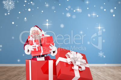 Composite image of santa standing in large gift