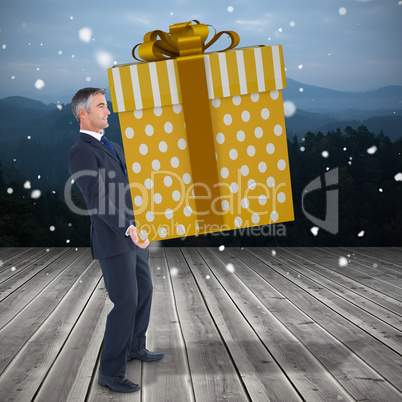 Composite image of stylish man with giant gift