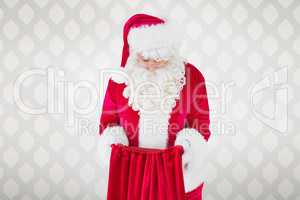 Composite image of santa claus looking in sack