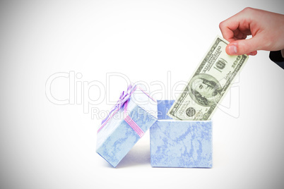 Composite image of hand holding hundred dollar bill