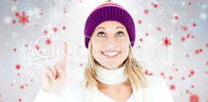 Composite image of bright woman with a colorful hat pointing upw