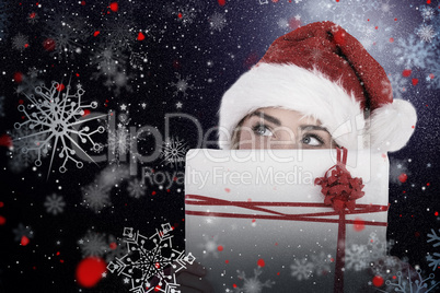 Composite image of festive blonde holding christmas gift
