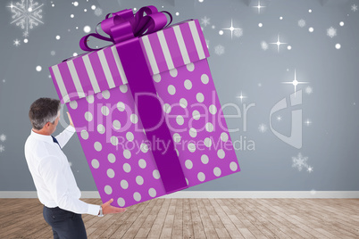 Composite image of stylish man with giant gift