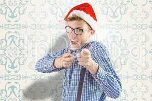 Composite image of geeky hipster wearing santa hat