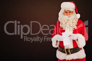 Composite image of happy santa holding paper and pen