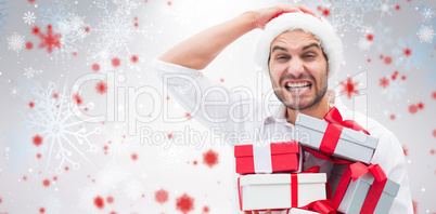 Composite image of festive man holding christmas gifts