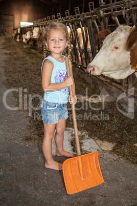 Mädchen spielt auf dem Bauernhof im Kuhstall