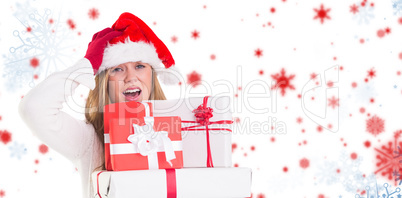 Composite image of festive blonde holding pile of gifts