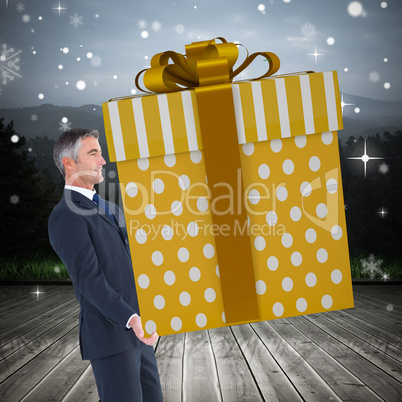 Composite image of stylish man with giant gift