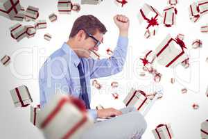 Composite image of businessman wearing glasses and using laptop