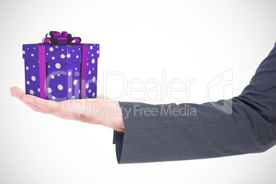Composite image of businessman holding his hand out