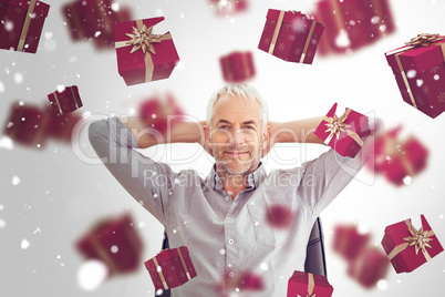 Composite image of relaxed mature businessman with hands behind