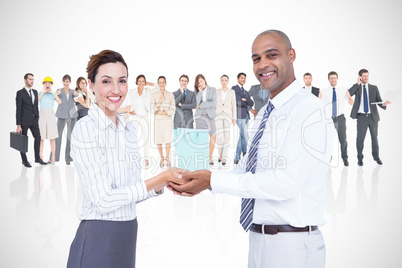 Composite image of business colleagues holding plant and looking