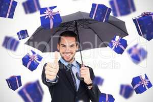 Composite image of positive businessman under umbrella with thum