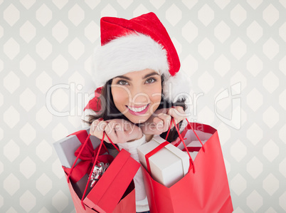 Composite image of smiling brunette holding shopping bags full o