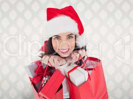 Composite image of smiling brunette holding shopping bags full o
