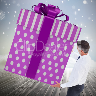 Composite image of stylish man with giant gift