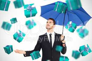 Composite image of cheerful businessman holding umbrella with ha