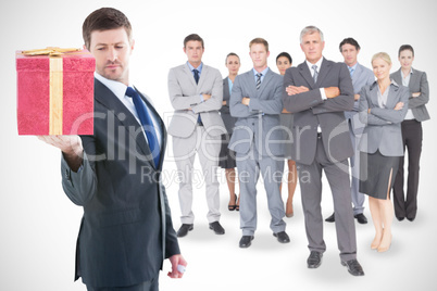 Composite image of businessman holding hand out in presentation