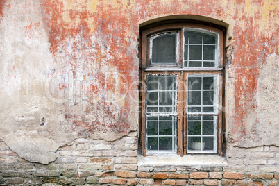 Weathered window and old shabby building wall