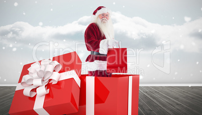 Composite image of santa standing in large gift