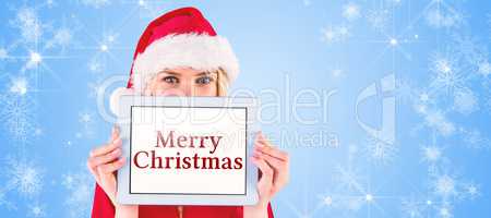 Composite image of festive blonde holding a tablet pc