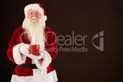 Composite image of santa holds a red cup