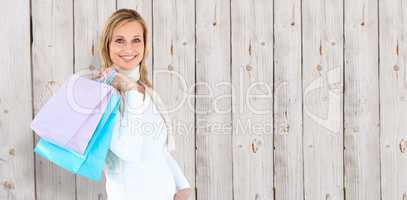 Composite image of handsome woman holding shopping bags against