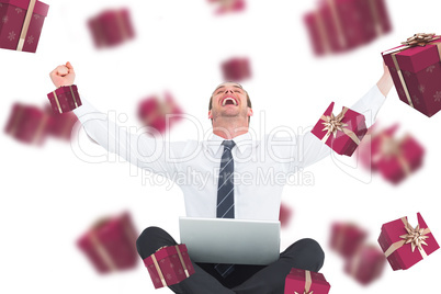 Composite image of businessman using laptop and cheering