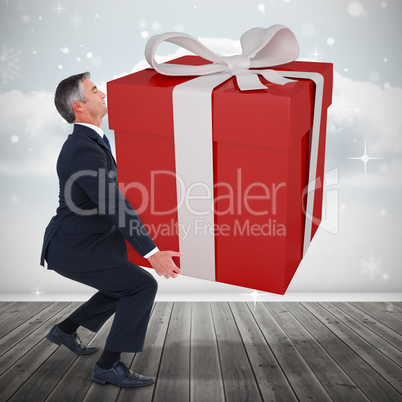 Composite image of stylish man with giant gift