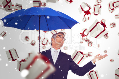 Composite image of businessman holding blue umbrella with hand o