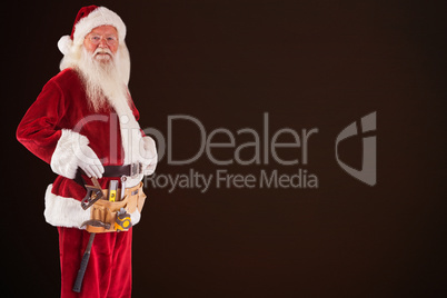 Composite image of father christmas is wearing a tool belt