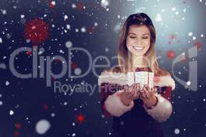 Composite image of pretty girl in santa outfit holding gift