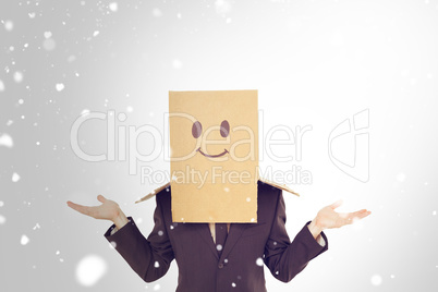 Composite image of businessman shrugging with box on head