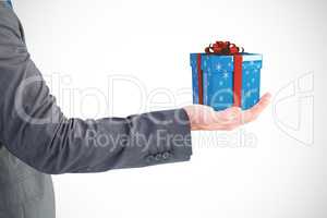 Composite image of businessman holding his hand out