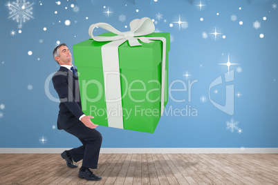 Composite image of stylish man with giant gift