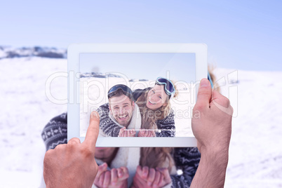 Composite image of hand holding tablet pc