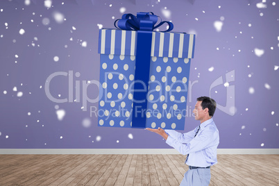 Composite image of stylish man with giant gift