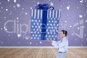 Composite image of stylish man with giant gift