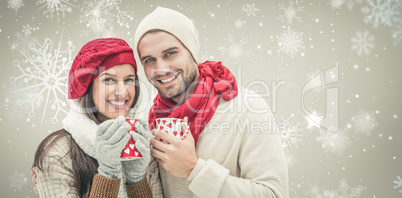 Composite image of winter couple holding mugs