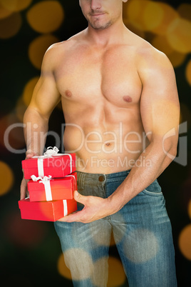 Composite image of muscular man holding pile of presents in blue