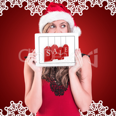 Composite image of festive blonde showing a tablet